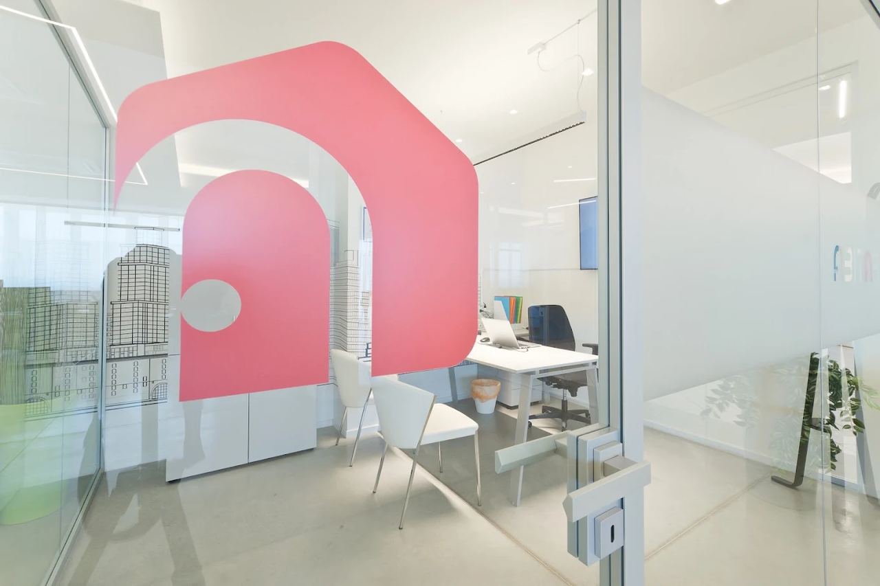 Il logo di Abitare sulla vetrata di una stanza dell'ufficio